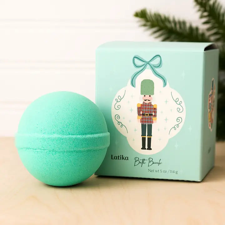 Green bath bomb with packaging featuring a nutcracker design on a light background