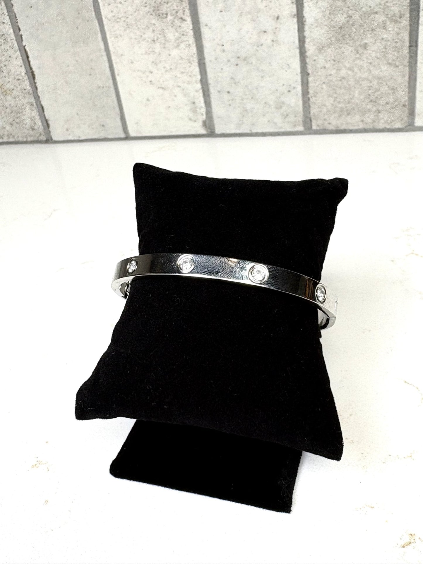 Chan Sutt Pearl silver minimalist bangle bracelet with embedded crystals side view on black cushion