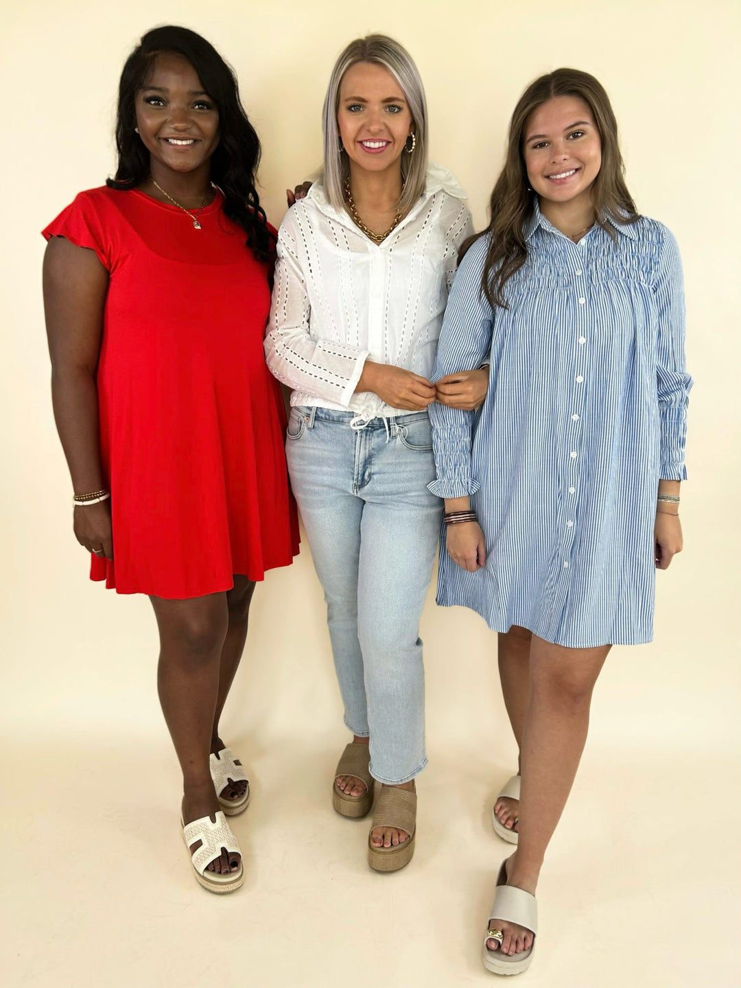 boutique summer outfits including red flowy dress, white eyelet blouse with light wash jeans, and blue striped button down dress