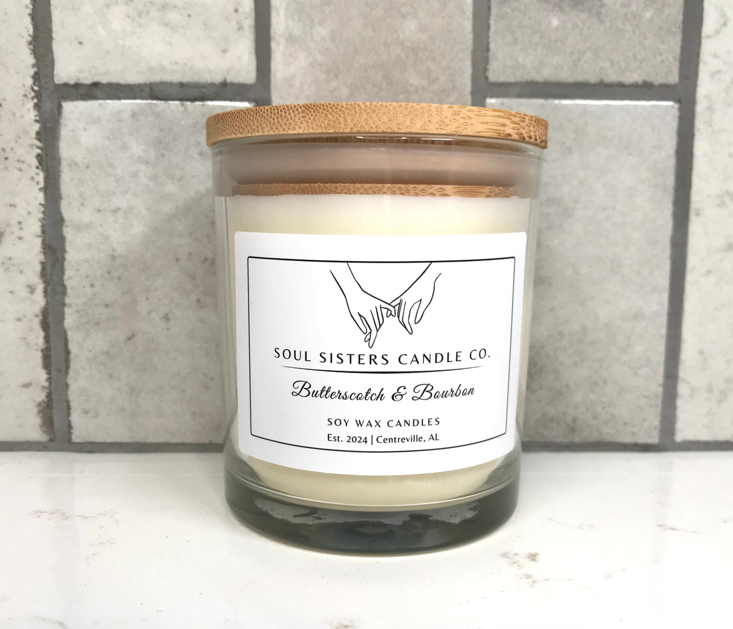 Scented candle with a wooden lid on a tiled surface