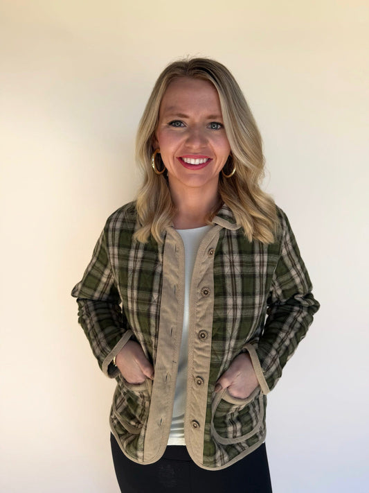 Front view of woman wearing a green and tan plaid jacket with corduroy button placket and pockets, styled over a white top.