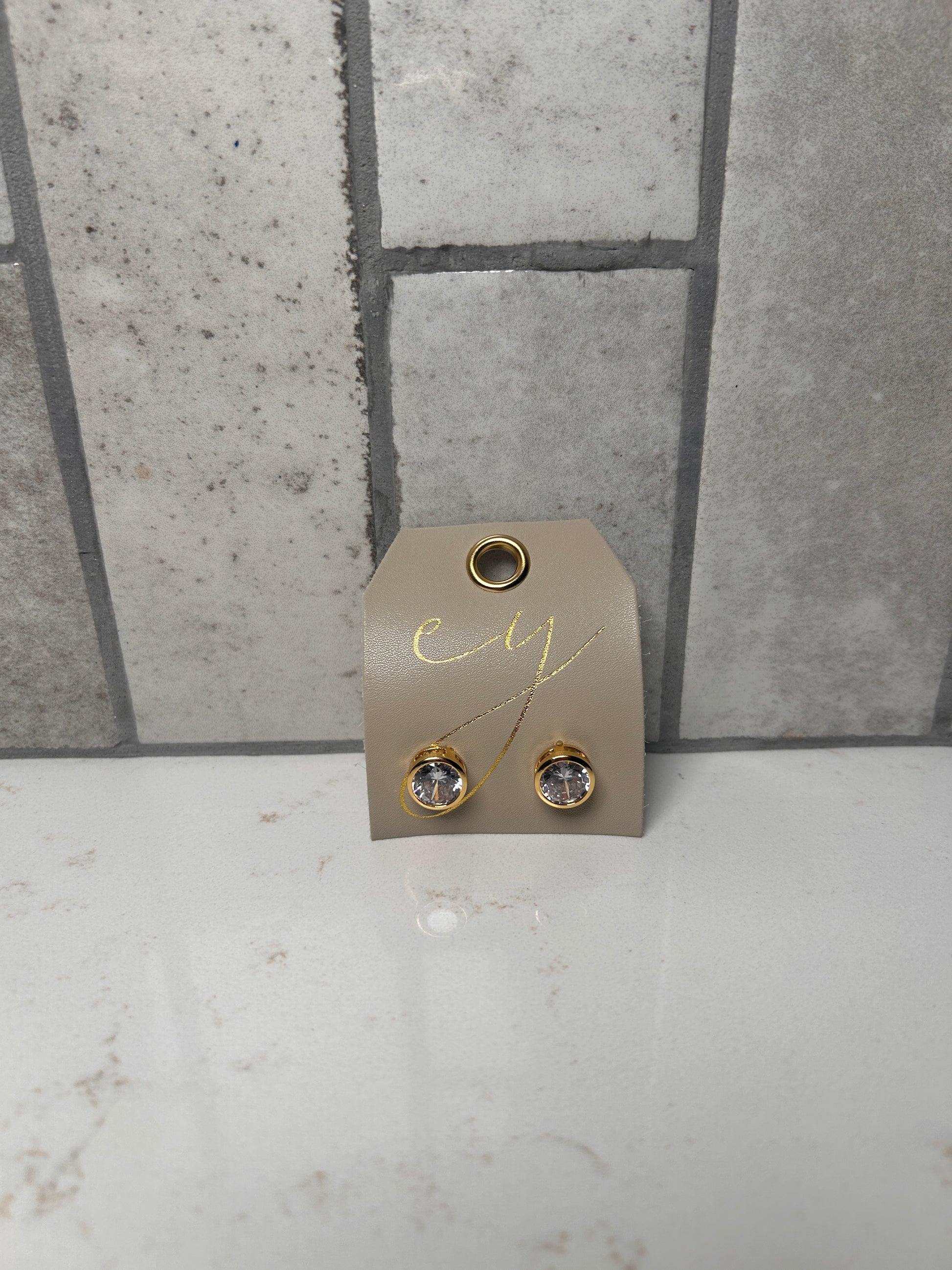 18K gold plated bezel stud earrings with round clear crystal on cream branded jewelry card, minimalist everyday studs