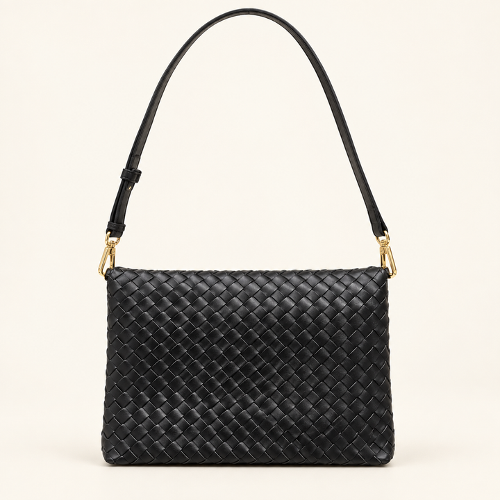 Wrenlee black woven flap bag styled with the shorter strap for shoulder carry.
