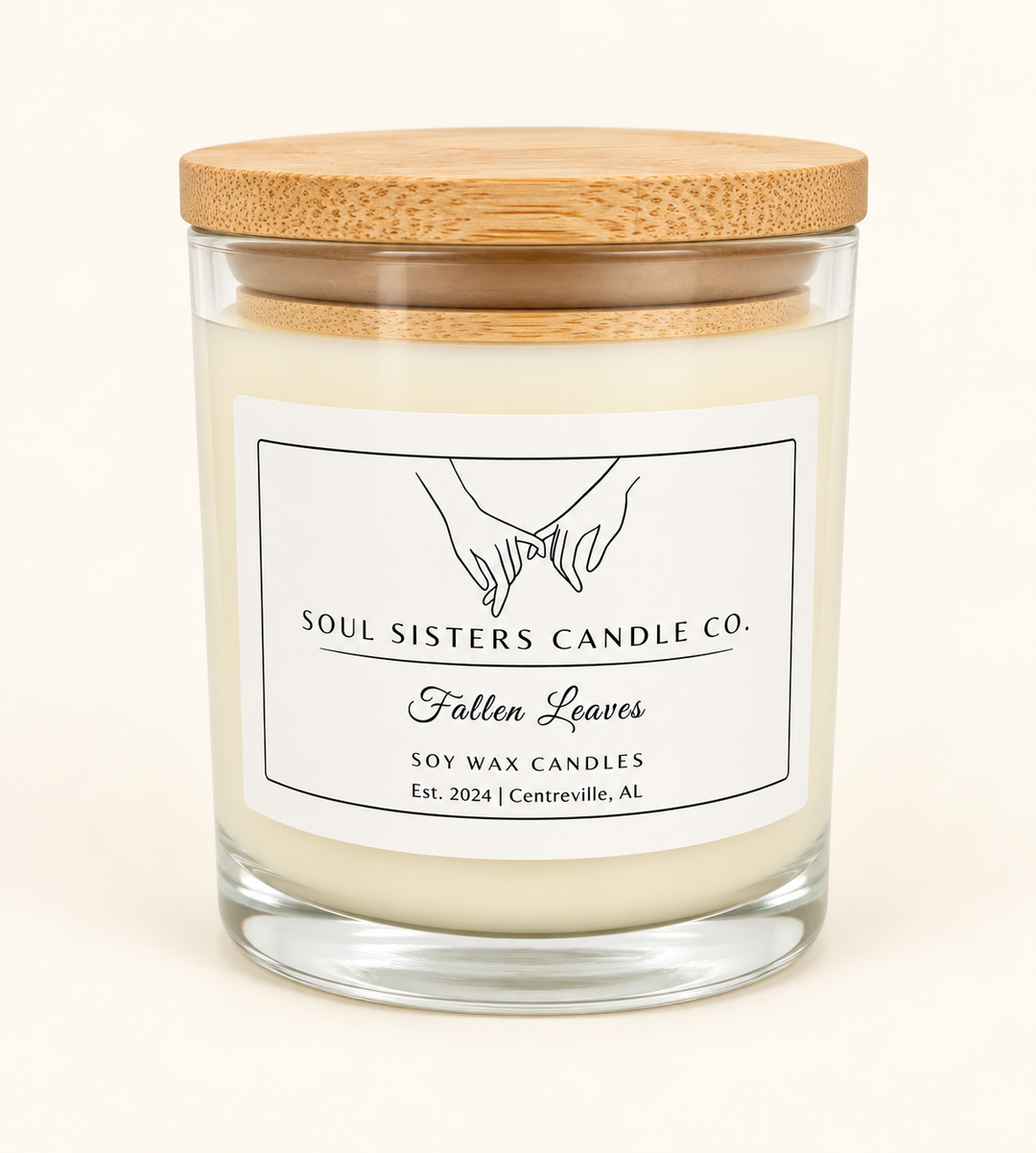 Soul Sisters Candle Co. Fallen Leaves soy wax candle in a clear glass jar with natural wood lid and white label, featuring a cozy autumn-inspired fragrance.