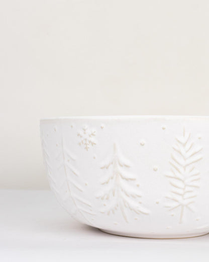 White ceramic bowl with leaf pattern on a white background