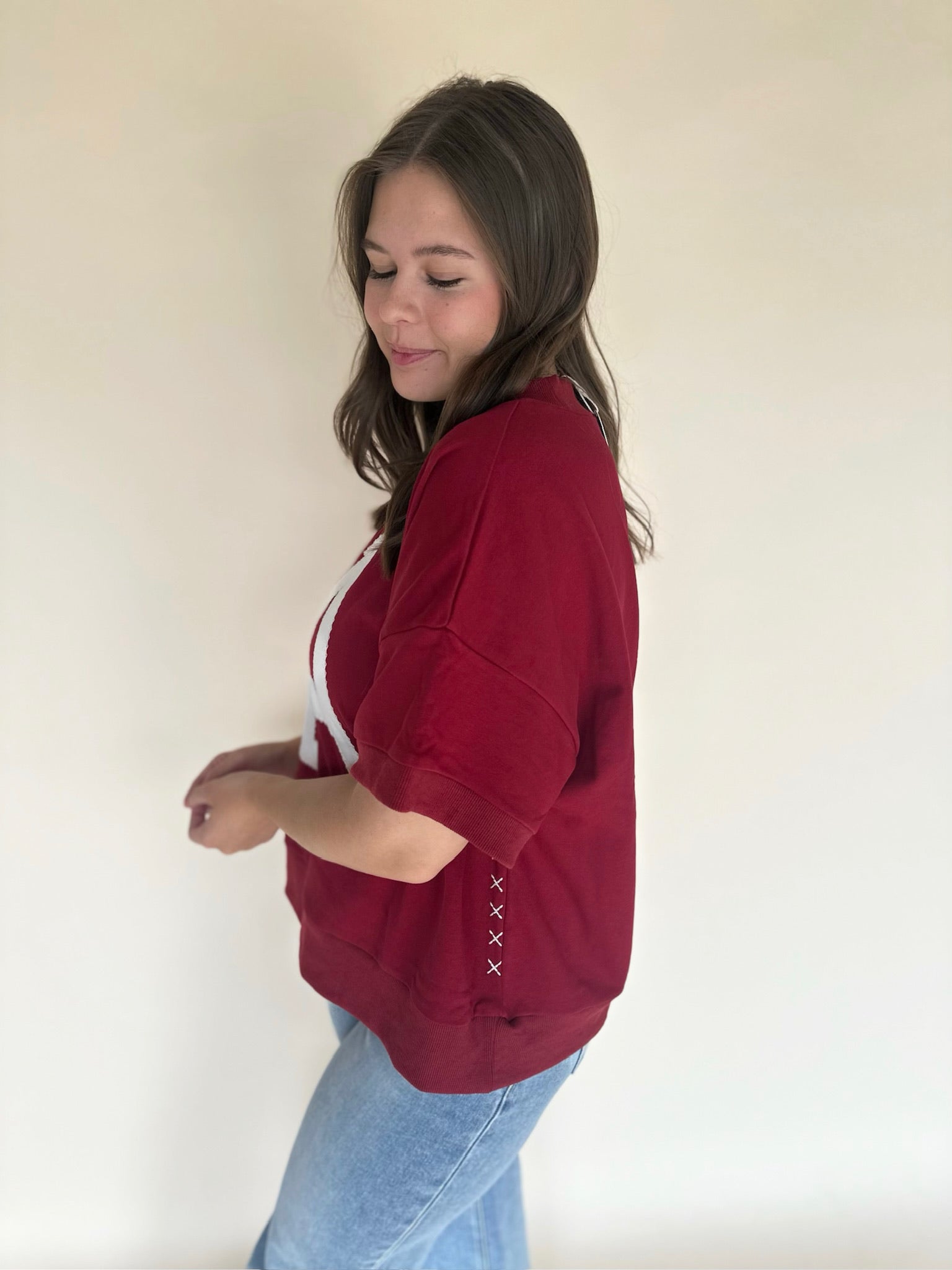 Person wearing a red sweatshirt with white accents against a plain background