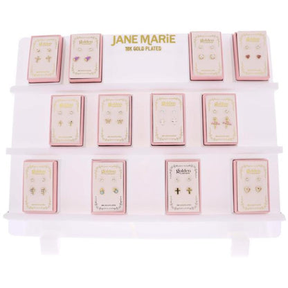 Jane Marie 18K gold-plated kids stud earring display featuring multiple pink boxed sets with assorted styles including hearts, crosses, butterflies, pearls, and colorful designs arranged on a white branded stand.