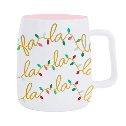 White mug with 'fa la la la' text and colorful lights design on a white background