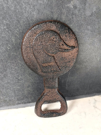 Rustic metal bottle opener with duck design on a gray background