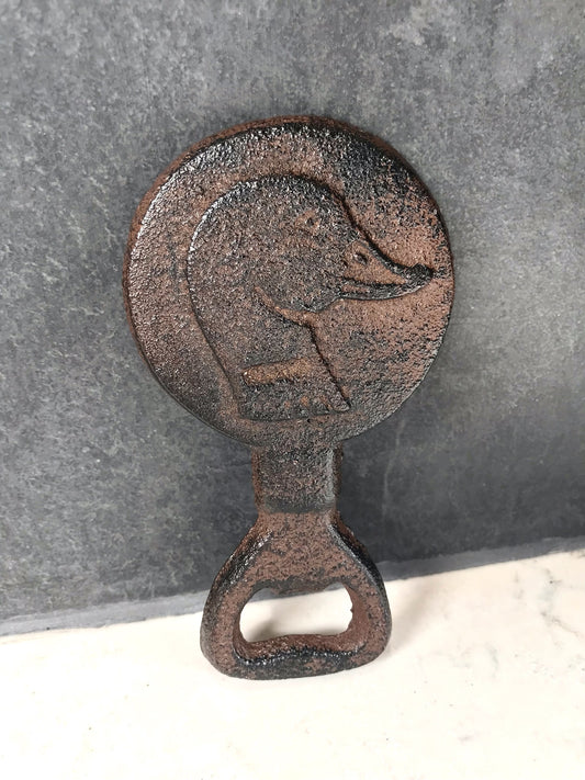Rustic metal bottle opener with duck design on a gray background