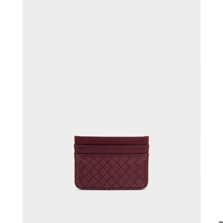 A small burgundy leather card holder with a quilted diamond pattern, centered on a light gray background.