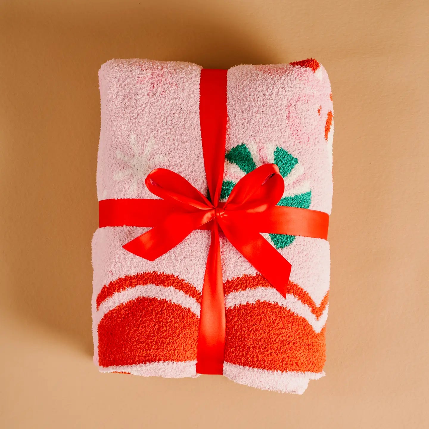 Folded towel with a red ribbon on a beige background