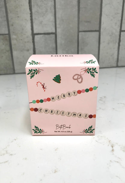 Pink Christmas-themed box on a white surface with a tiled wall background