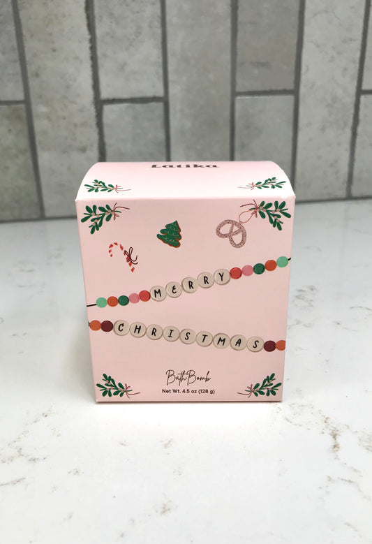 Pink Christmas-themed box on a white surface with a tiled wall background