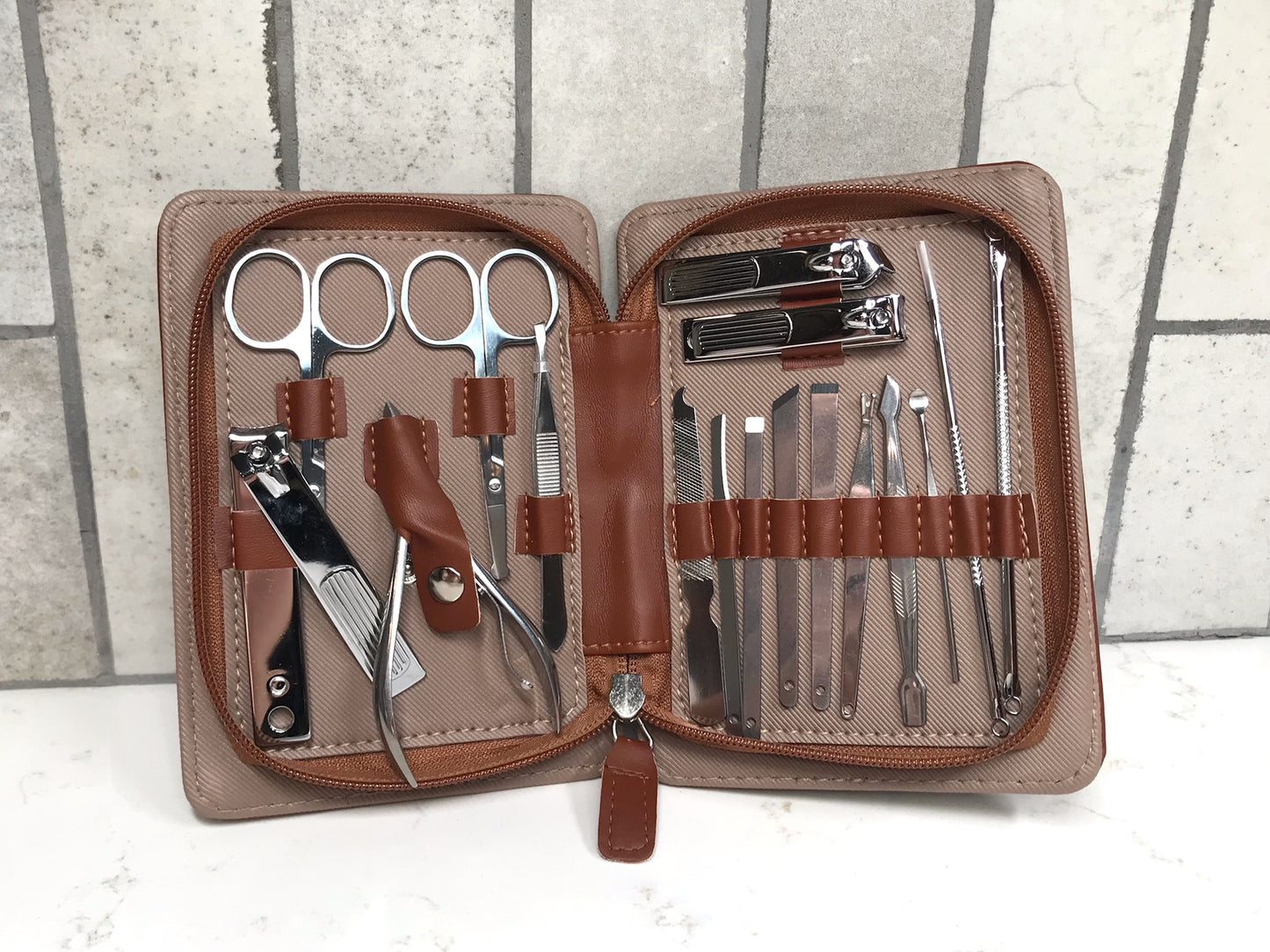Manicure set with tools in a brown case on a white background