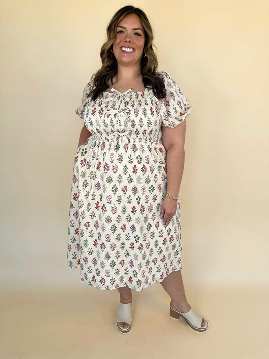 Camille Plus Block Print Bow Dress in cream floral print featuring smocked bodice, puff sleeves, and decorative front bow details