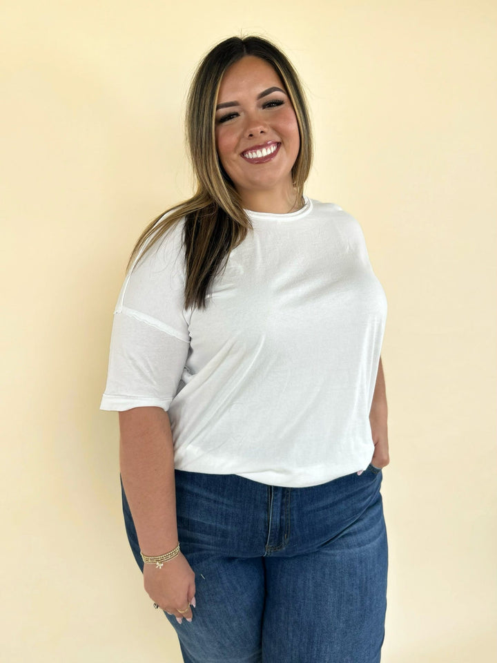 white oversized short sleeve tee styled with dark wash denim jeans casual women’s boutique outfit