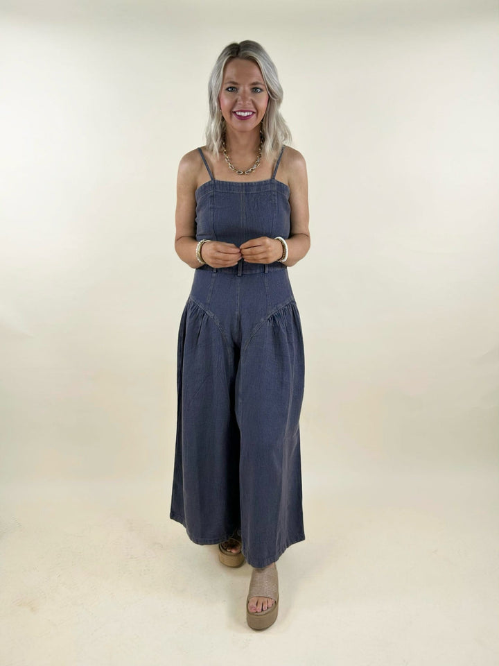 blue denim wide leg jumpsuit front view belted waist sleeveless casual chic women’s outfit
