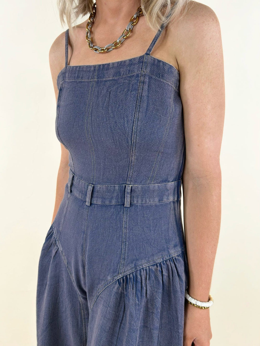 blue denim sleeveless jumpsuit close up front bodice detail adjustable straps belted waist