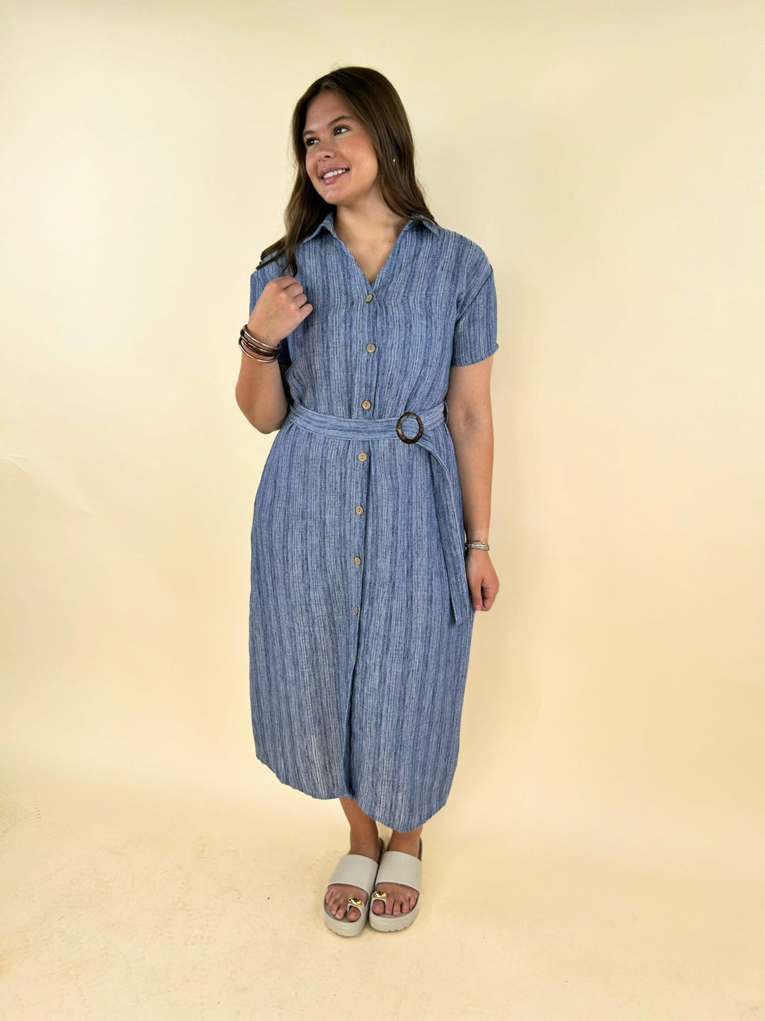 Front view of blue striped midi dress with belt, short sleeves, button front, casual chic women’s boutique outfit