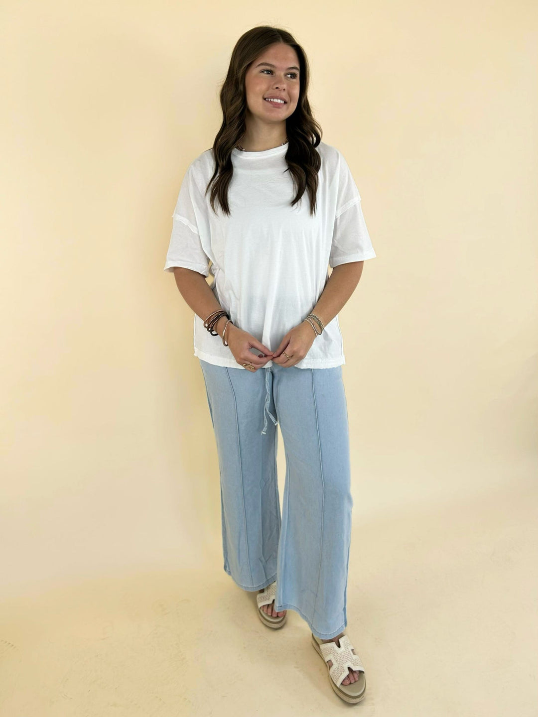 white oversized tee styled with light blue wide leg pants casual lounge women’s boutique outfit