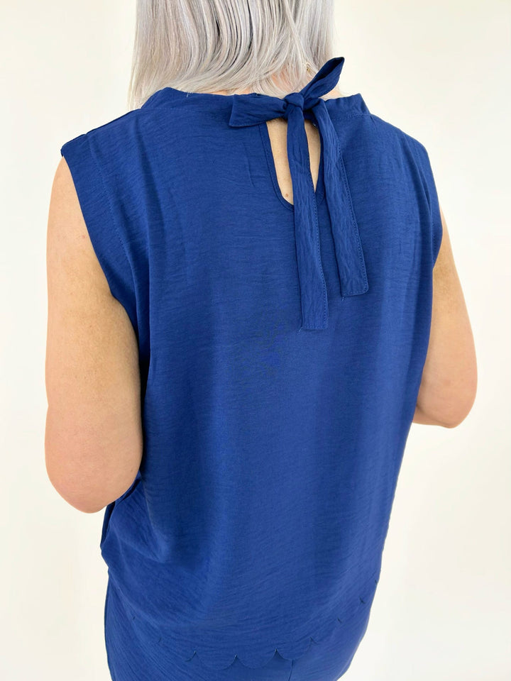 Back detail of navy sleeveless top featuring tie neckline and soft lightweight fabric