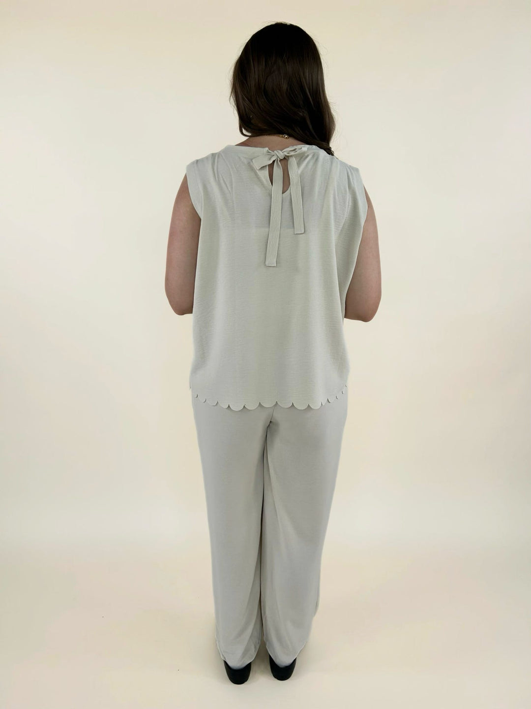 Back full view of cream two piece set with scalloped hem top and relaxed wide leg pants