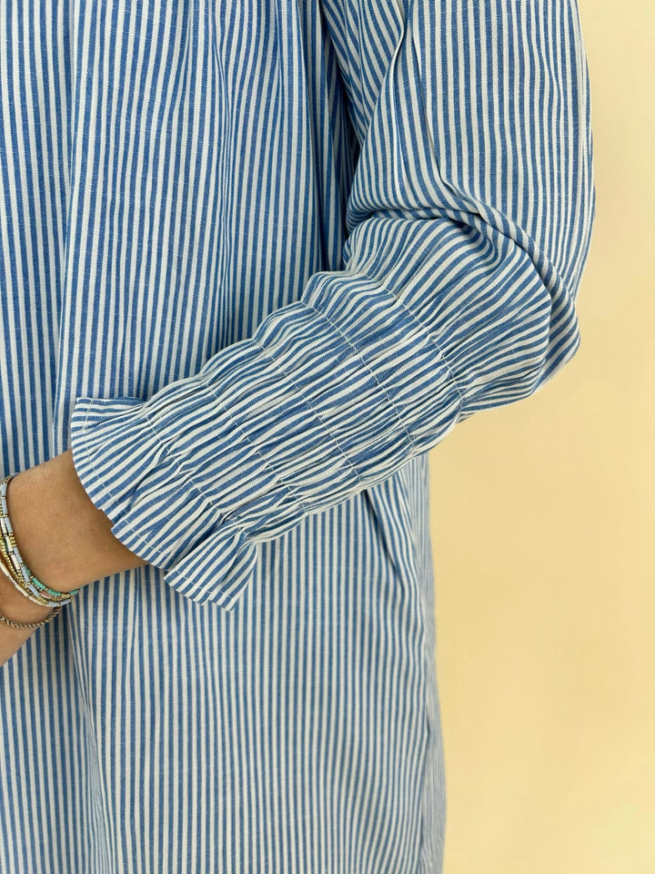 Close up of long sleeve cuff on blue and white striped dress showing gathered elastic sleeve detail