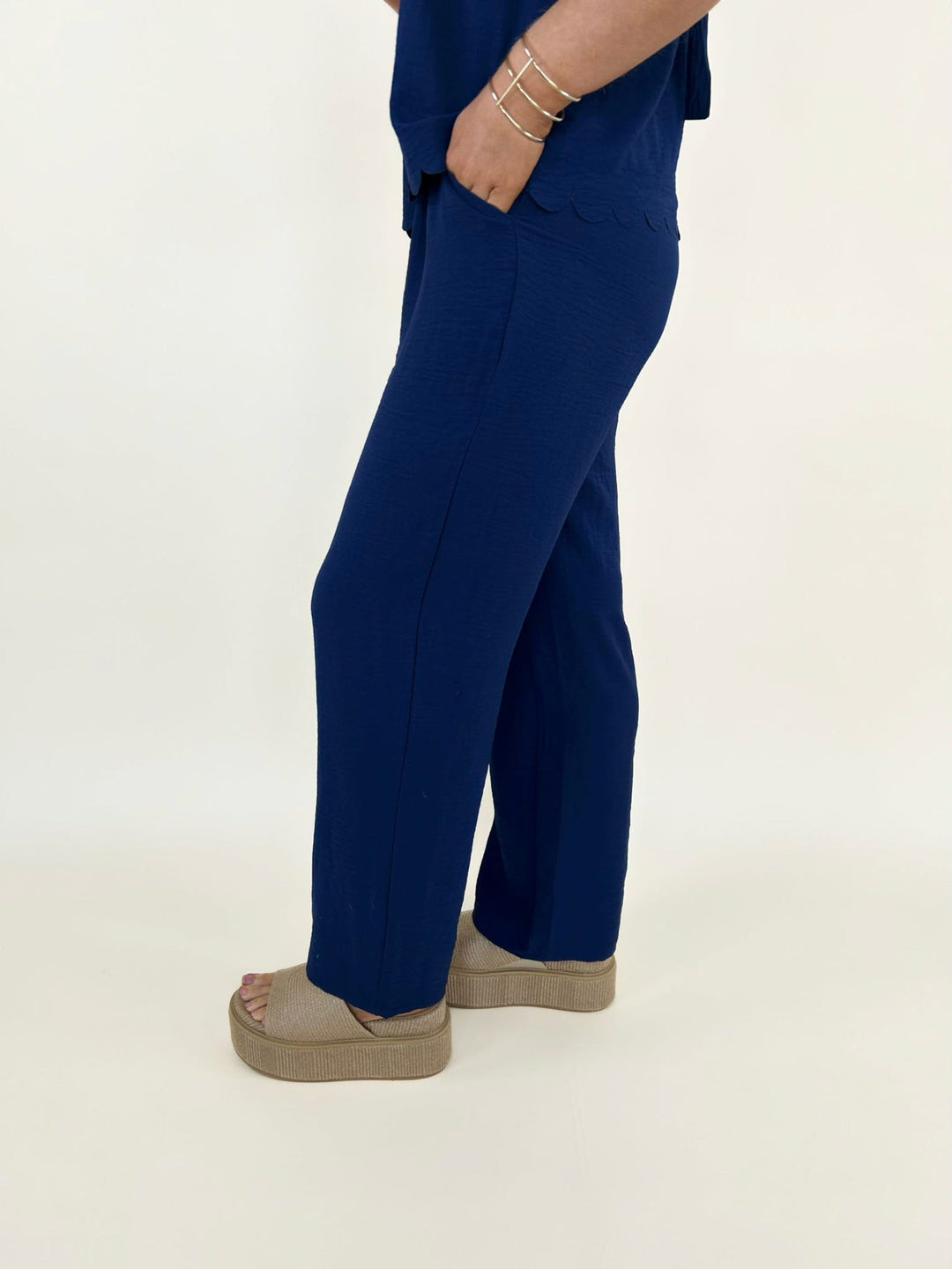 Side view of navy blue pants with pocket detail and relaxed fit