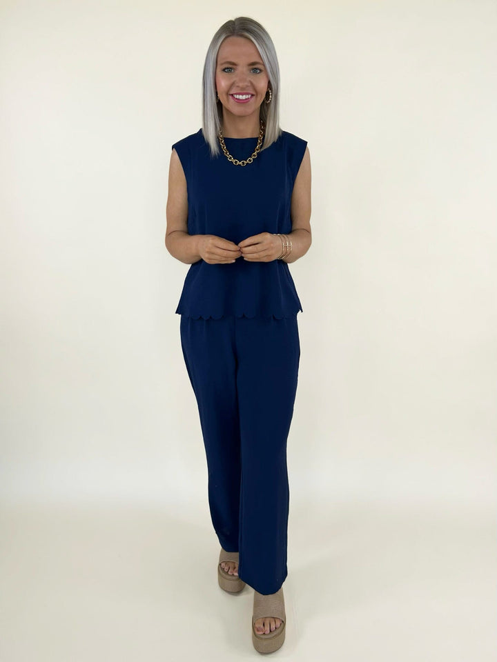 Front full body view of navy two piece set with sleeveless scalloped hem top and wide leg pants