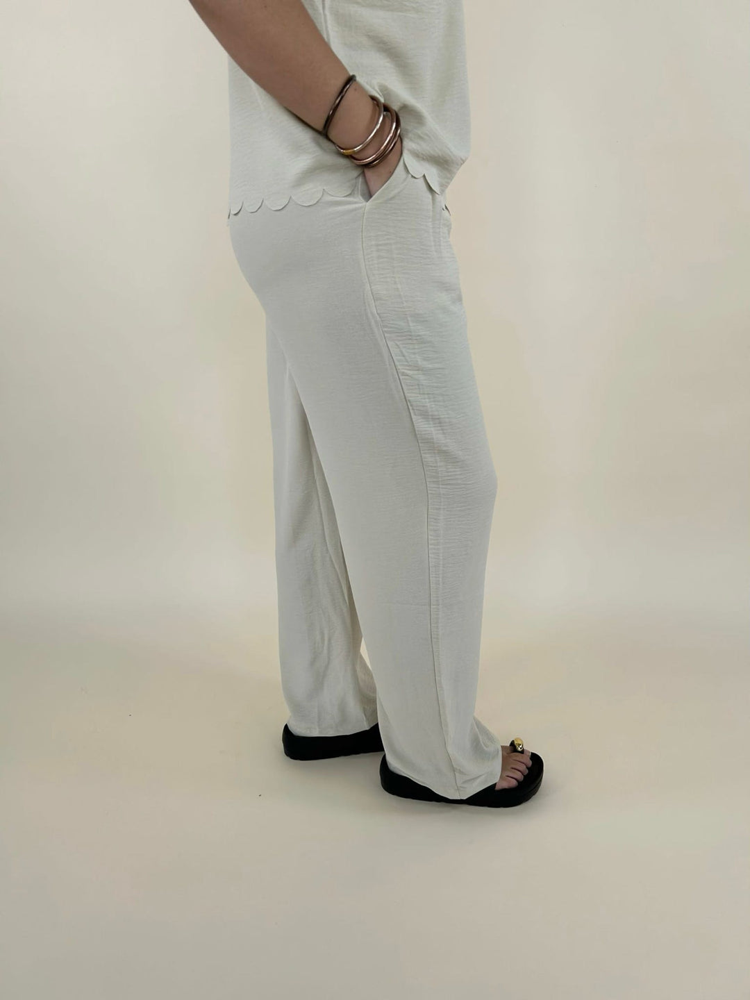 Side view of cream lounge set pants with pocket detail and relaxed wide leg fit