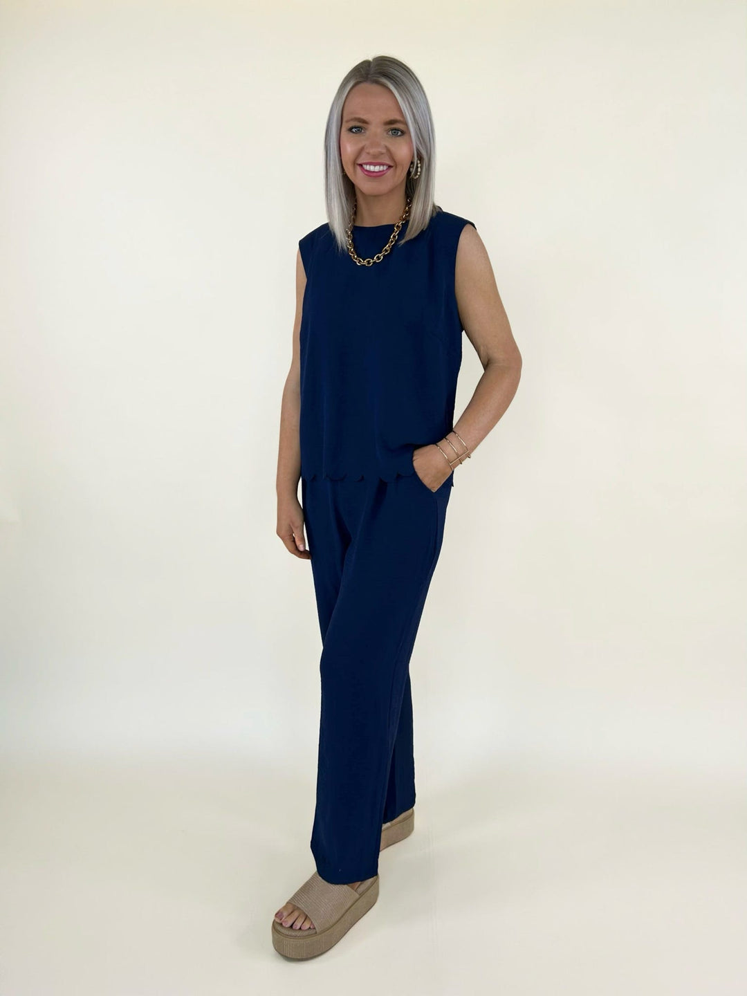 Side front view of navy sleeveless top and wide leg pants styled with neutral platform sandals