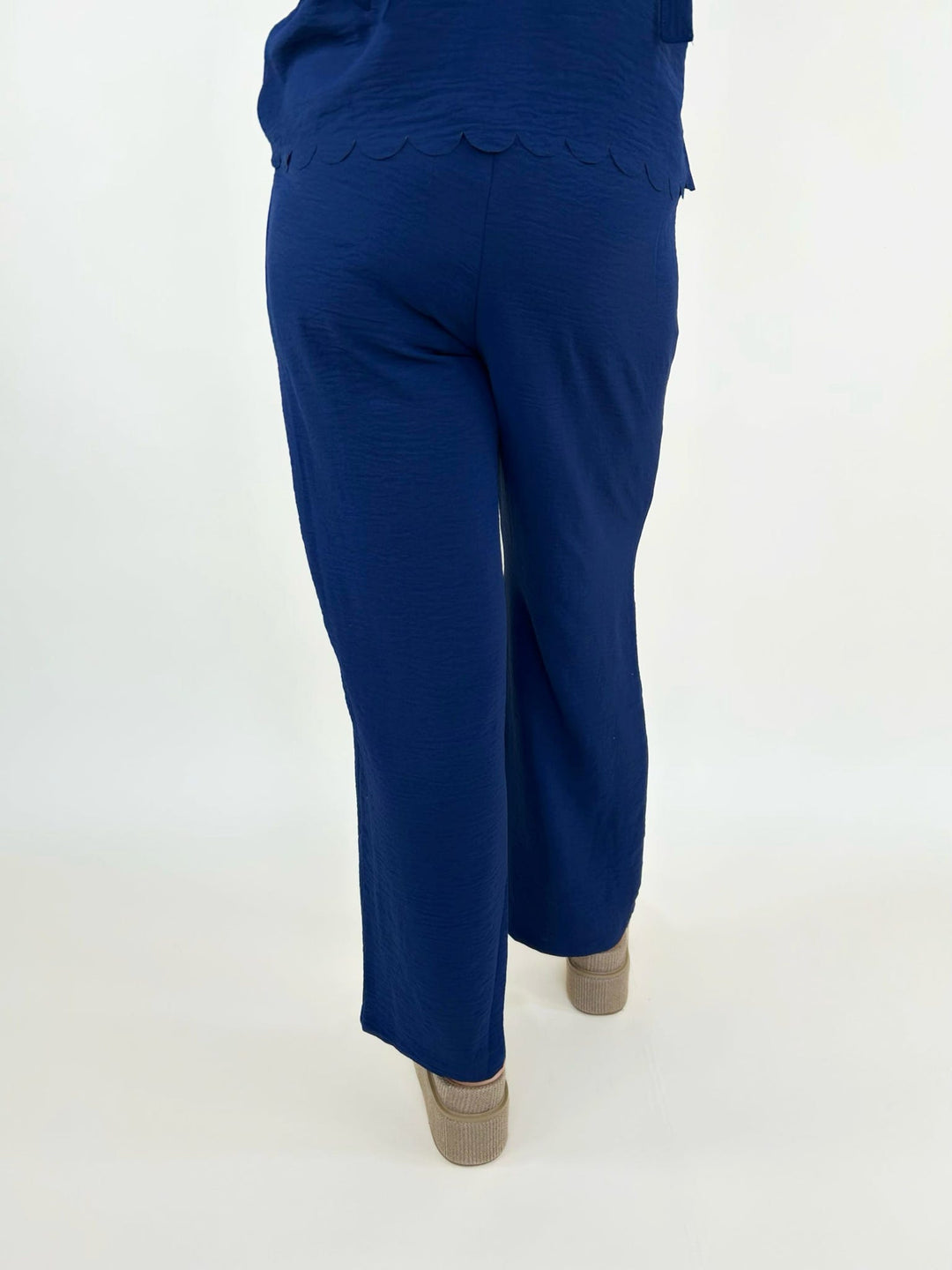 Back view of navy blue wide leg pants styled with platform sandals