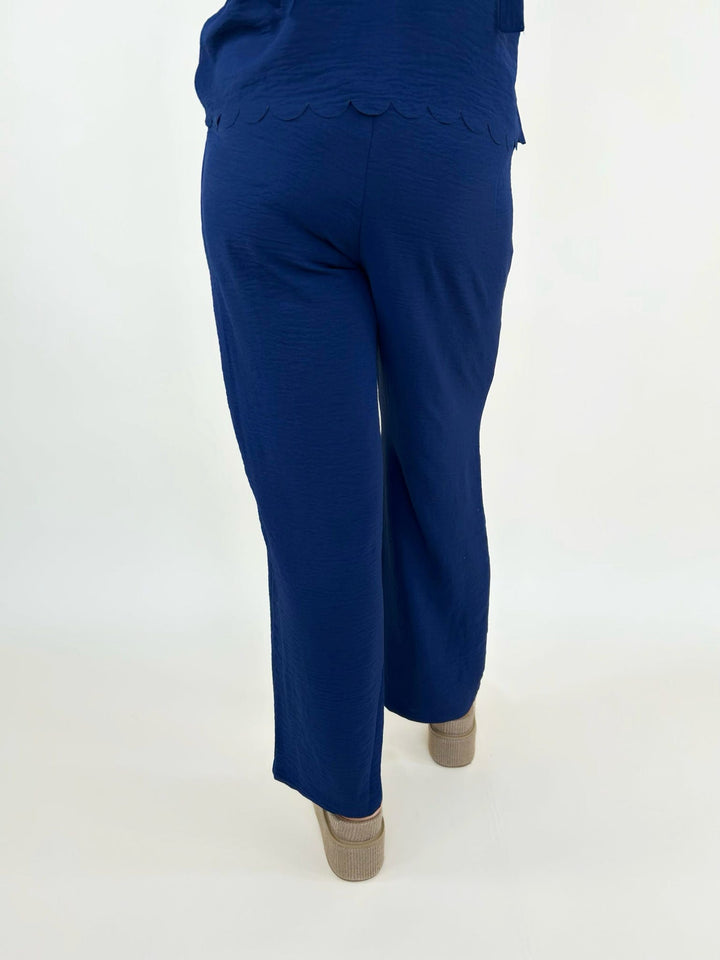 Back view of navy blue wide leg pants styled with platform sandals