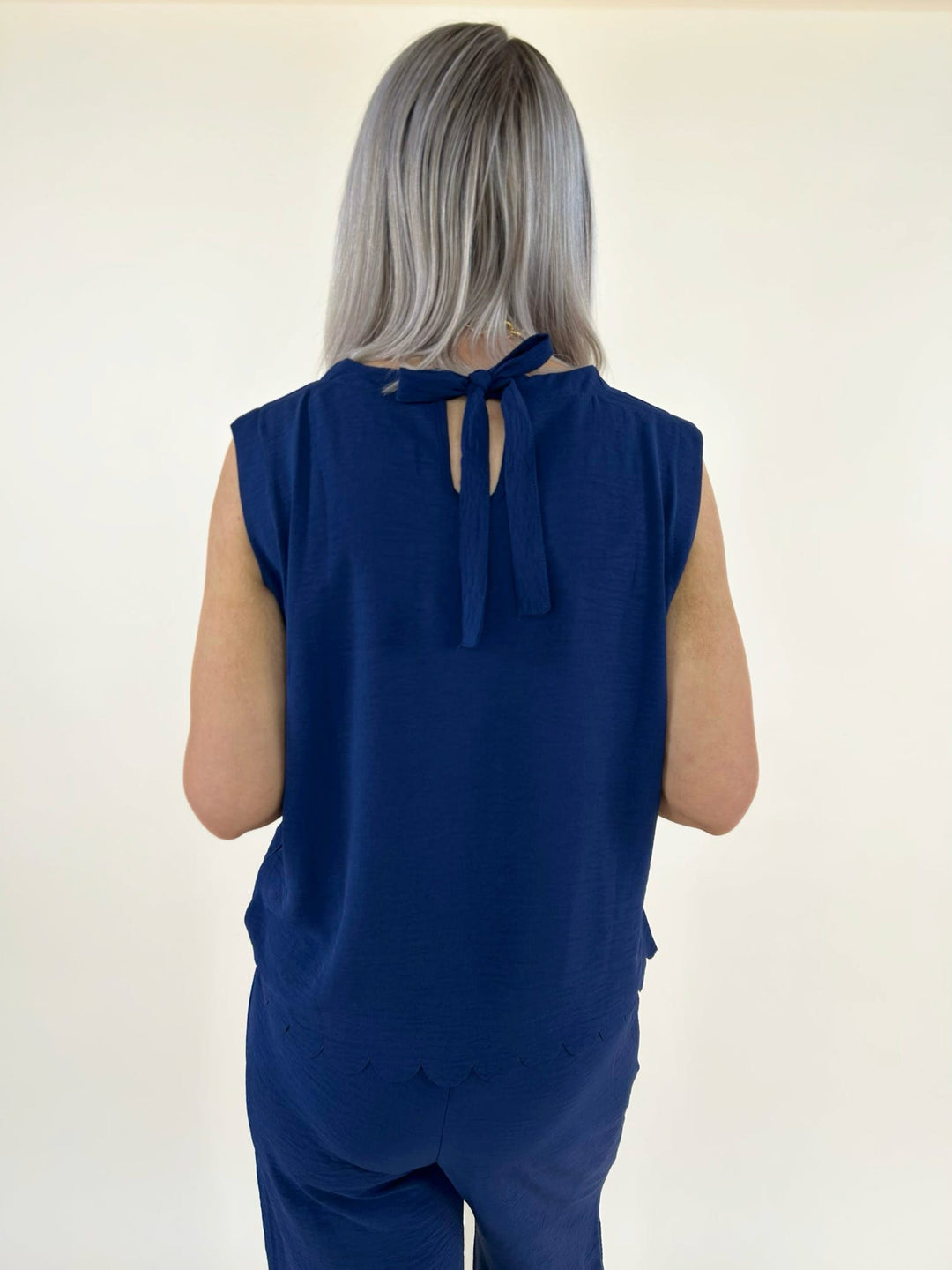 Back full view of navy two piece set with scalloped hem top and wide leg pants