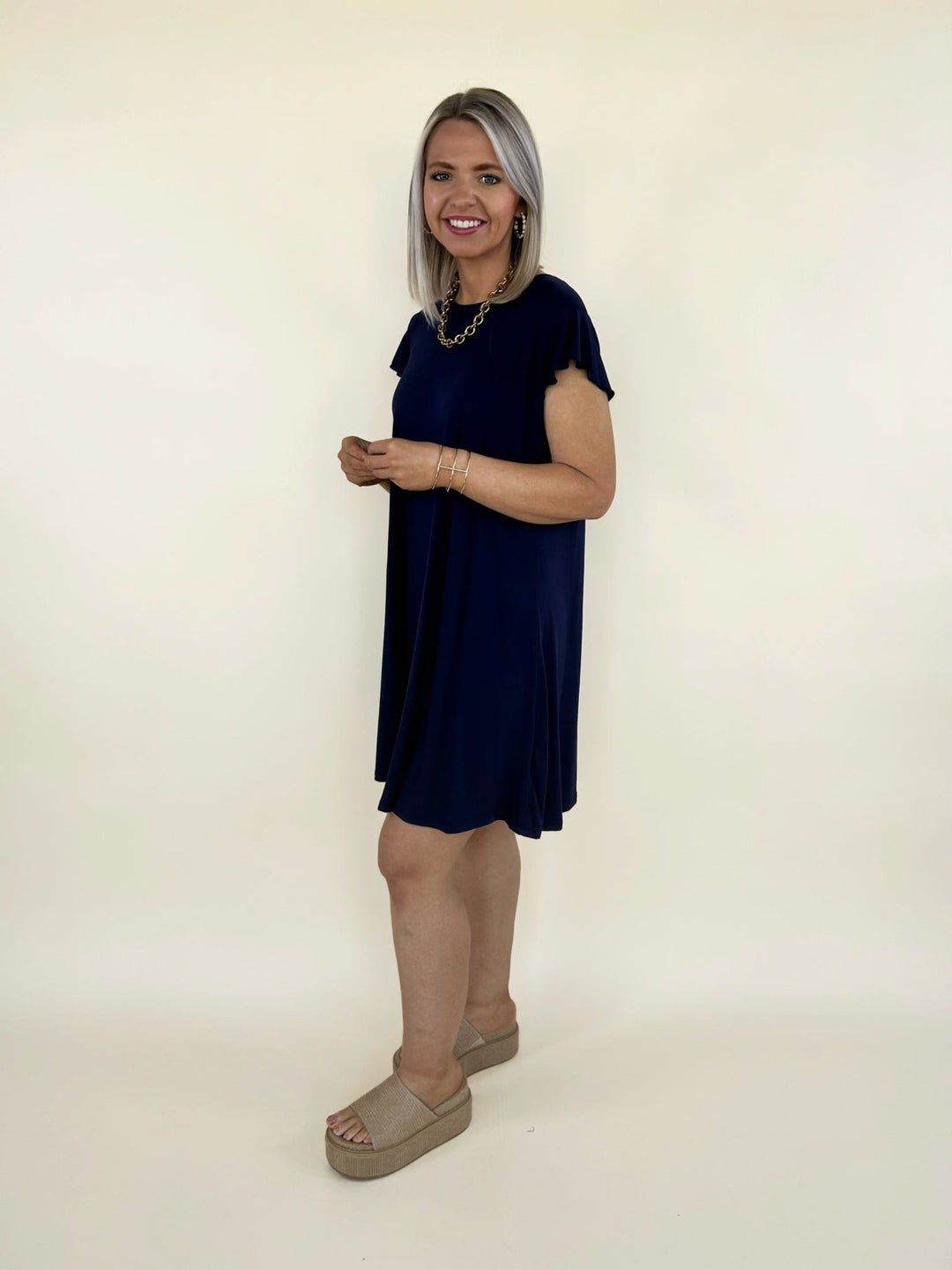 Side view of navy short sleeve swing dress with flowy silhouette and soft lightweight fabric