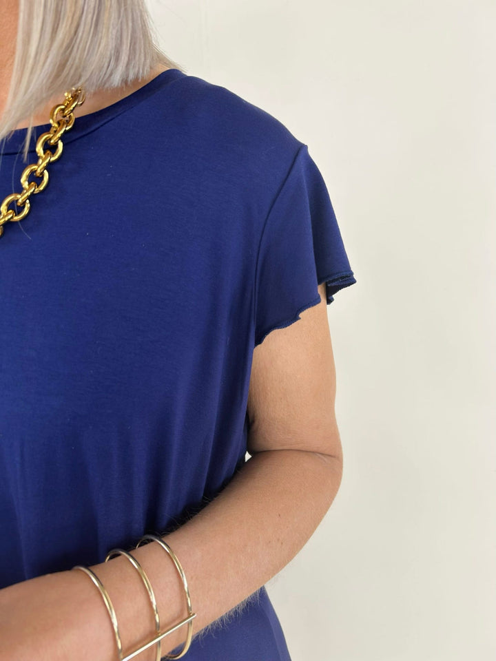 Close up detail of navy short sleeve dress showing soft fabric and flutter sleeve design