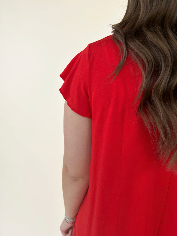 Close up detail of red short sleeve swing dress showing flutter sleeve and soft lightweight fabric