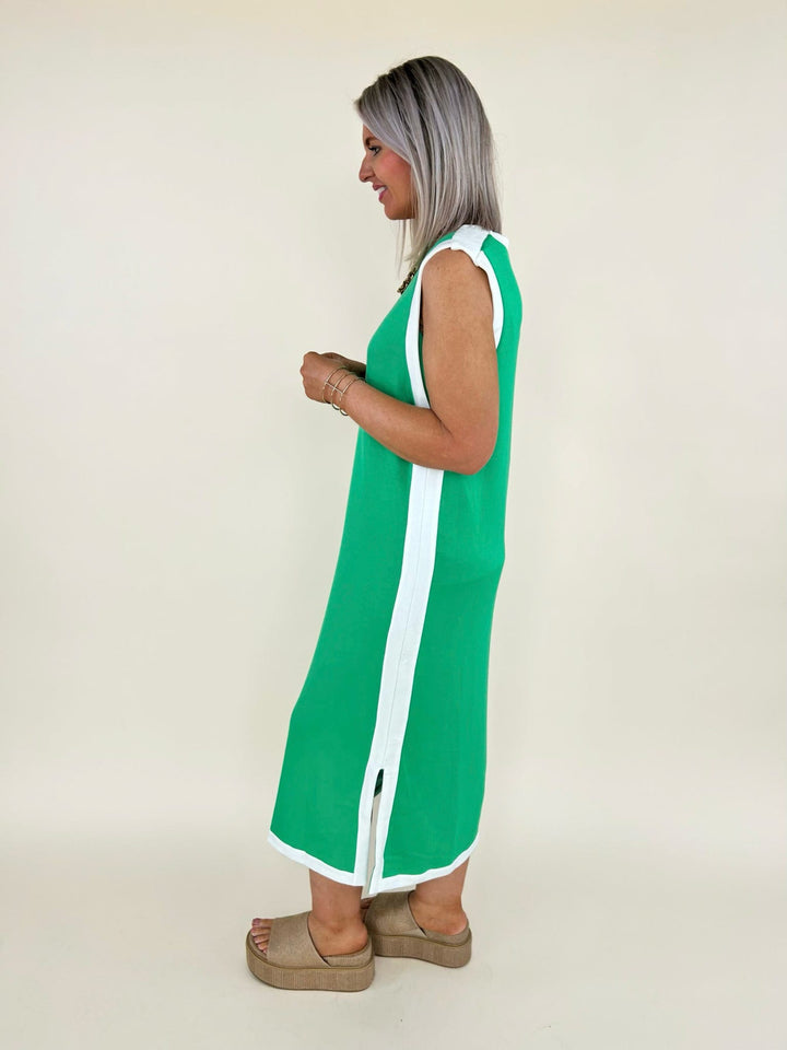 Side view of green sleeveless midi dress with white side panel detail and slit, styled with platform sandals