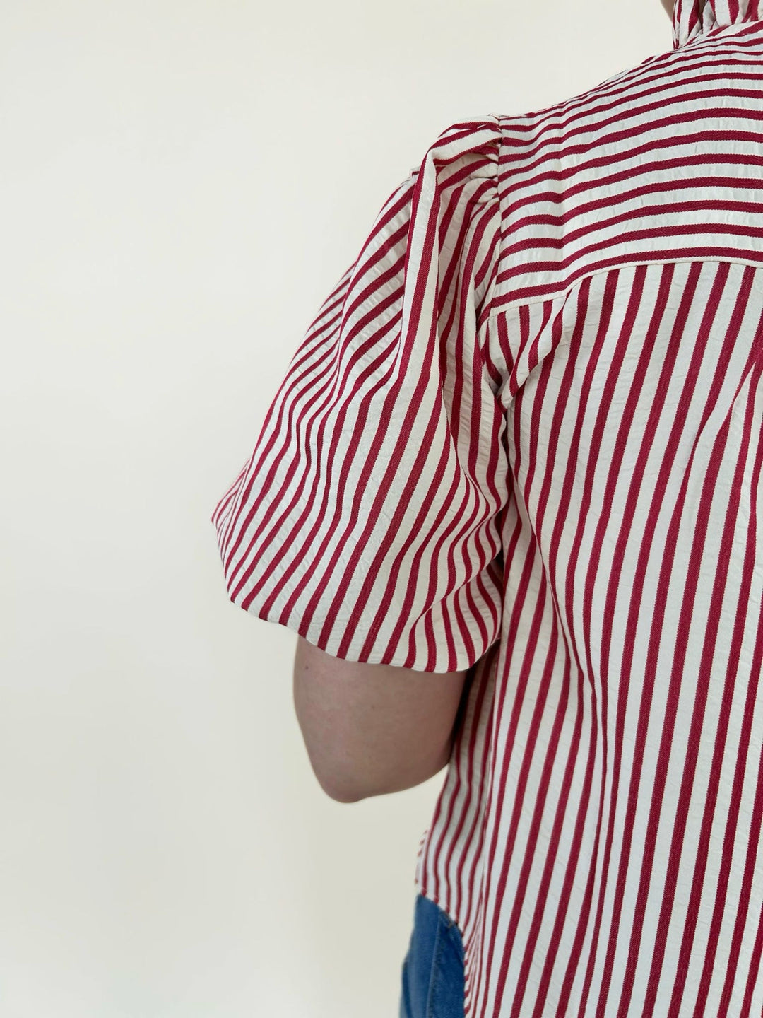 Close up of red and white striped puff sleeve blouse showing sleeve detail and textured fabric