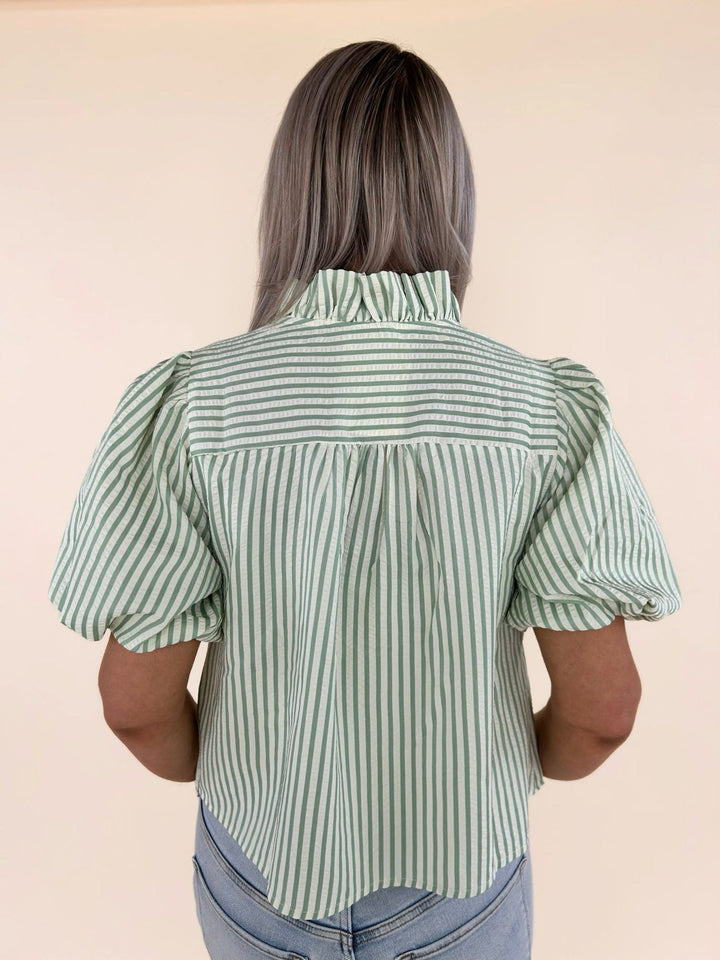 Close-up back detail of green and white striped blouse showing gathered yoke and vertical stripe pattern
