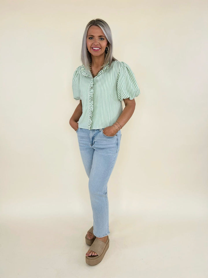 Green and white striped ruffle blouse styled with light wash straight leg jeans and platform sandals, front view women’s boutique outfit