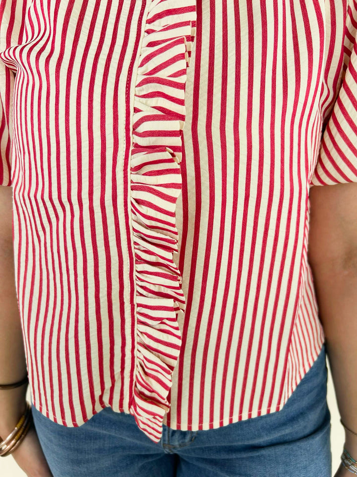 Close up of red and white striped ruffle front blouse detailing vertical stripes and button front design