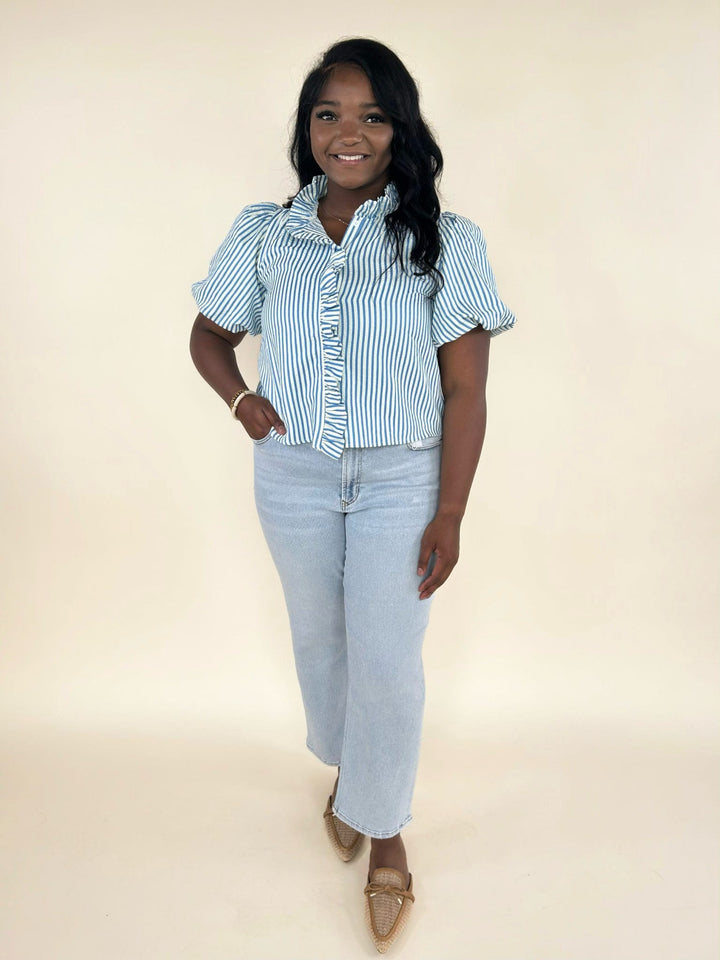 Blue and white striped ruffle blouse styled with light wash cropped jeans and woven pointed toe flats, front view women’s boutique outfit