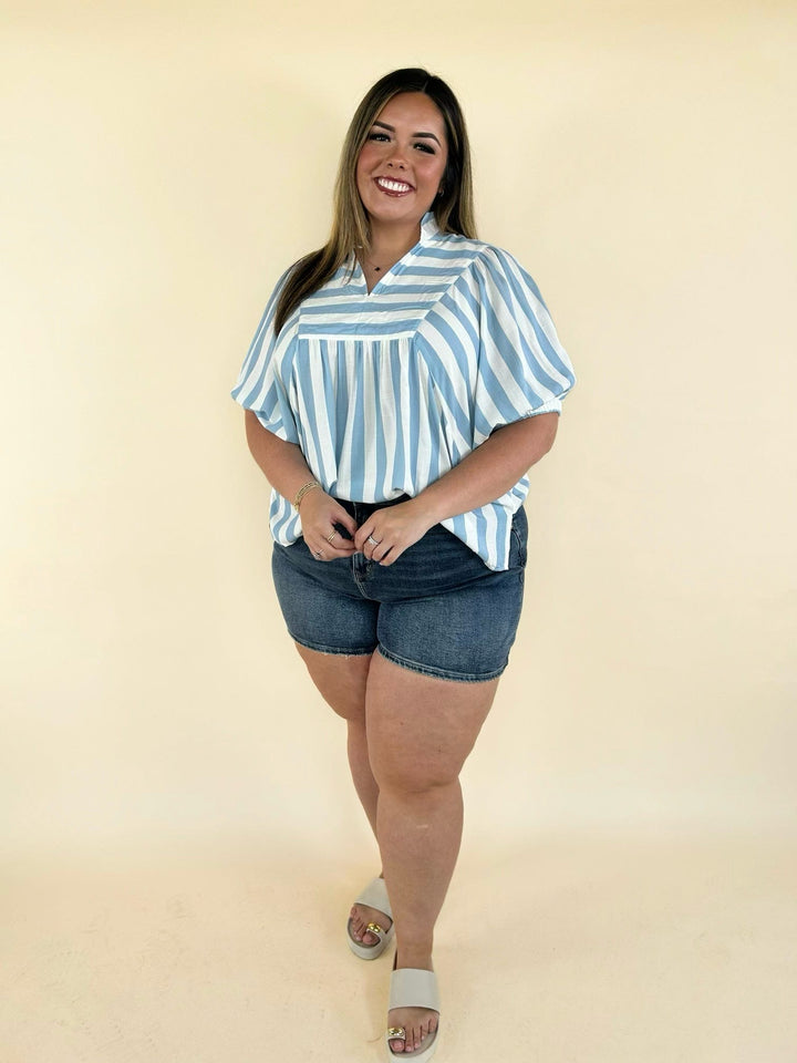 Blue and white striped collared blouse with puff sleeves styled with denim shorts, front full body view