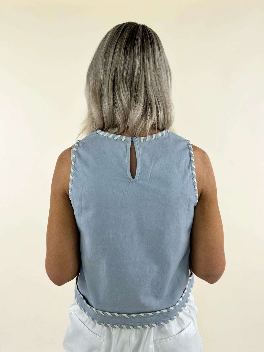 Sleeveless light blue tank with contrast whip stitch trim and keyhole back detail.