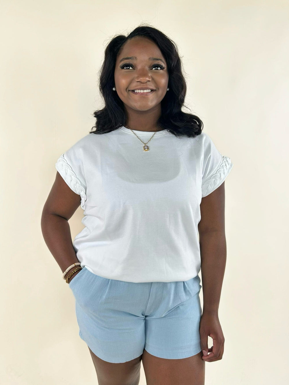 Women's white braided sleeve blouse with crew neck, decorative braided sleeve accents, and relaxed everyday fit