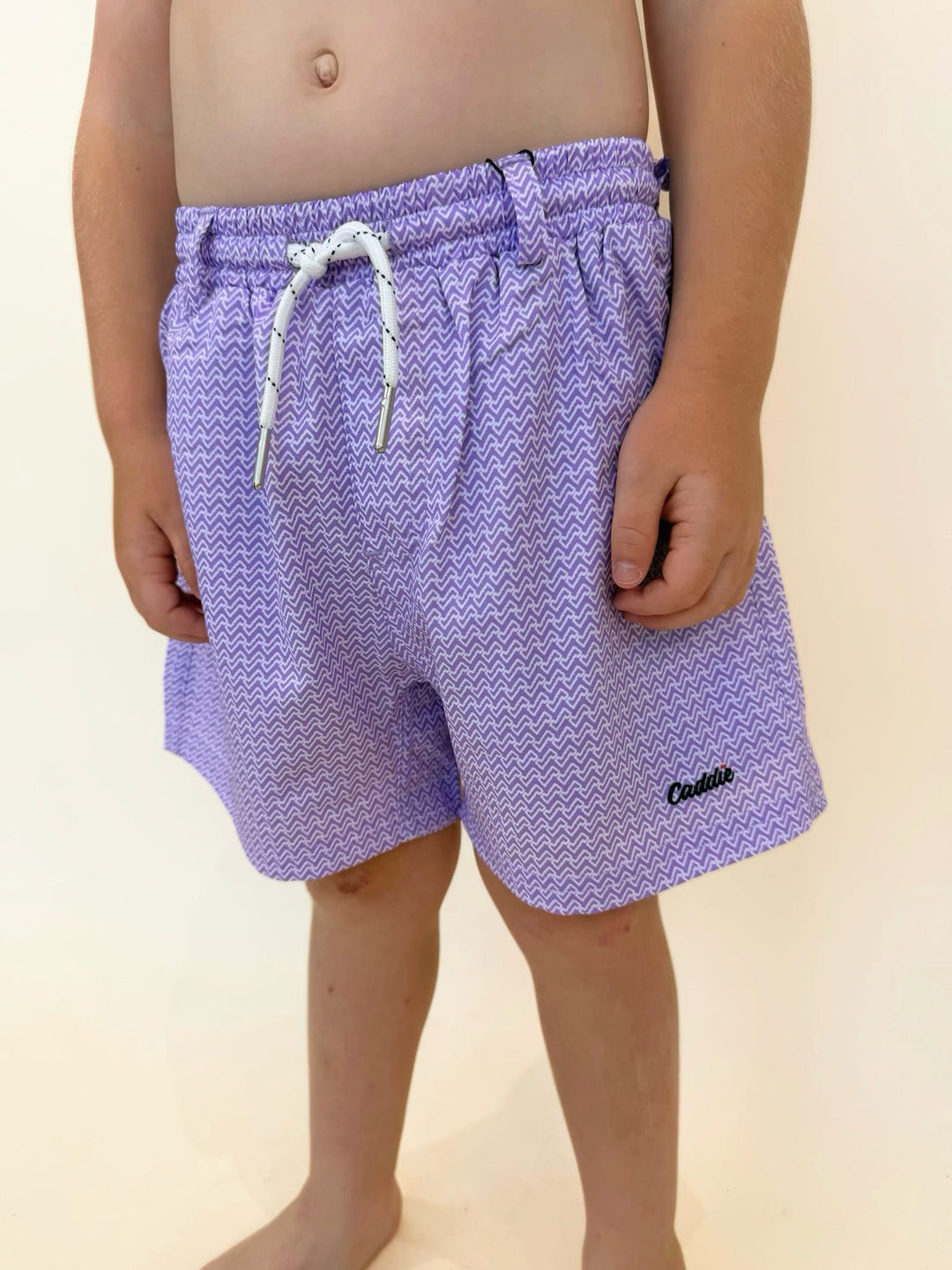 Youth purple swim trunks, boys patterned swim shorts, Caddie youth swimwear, boys beach shorts, lightweight boys swim trunks, quick dry swim shorts, purple summer swimwear, boys vacation essentials