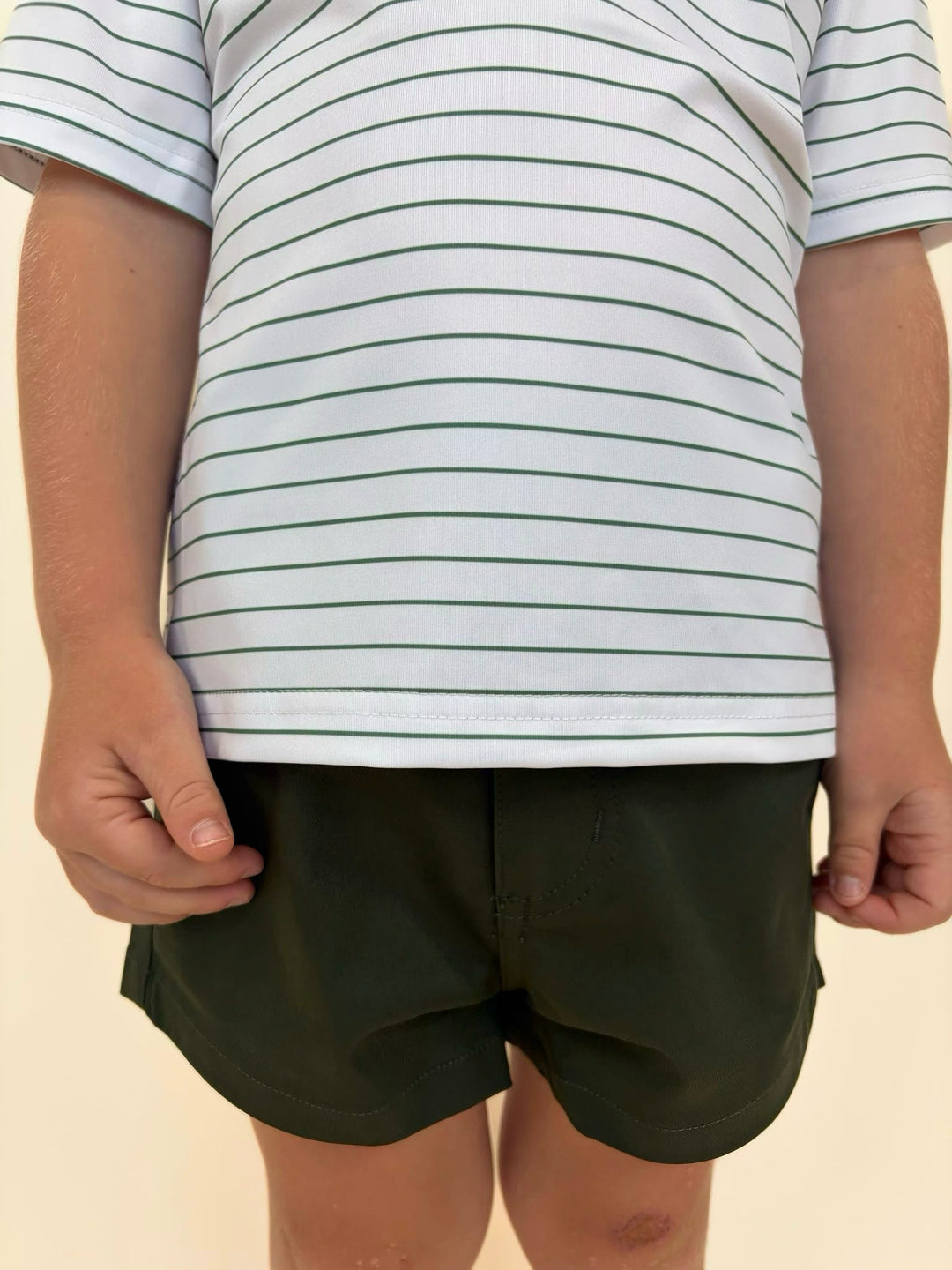 Youth boys performance outfit featuring Fieldstone striped polo and black athletic shorts, comfortable outdoor apparel for active kids