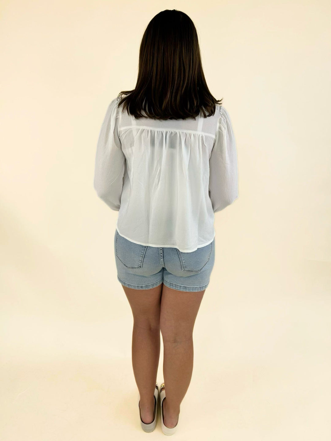 Back view of Dear John light wash high-rise denim shorts showcasing a comfortable fit, classic back pockets, and a clean finished hem.